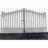 Large pair of wrought iron entrance gates of upright rail form with gilt pike detail and with arched