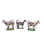 Group of three early 19th century Staffordshire cow creamers, two with sponged puce and red