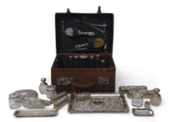 Edwardian leather travelling case with a majority of the original fittings including five silver