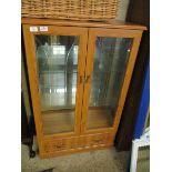 PINE EFFECT TWO GLAZED DOOR DISPLAY CABINETS WITH FULL WIDTH DRAWER TO BASE
