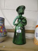 UNUSUAL POTTERY SCULPTURE OF A WOMAN WITH JAR UNDER HER ARM, GREEN GLAZED WITH MONOGRAM JJ TO