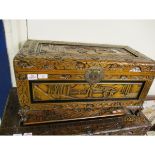 SMALL CAMPHOR WOOD CARVED ORIENTAL TRUNK WITH DECORATIVE LOCK RAISED ON SQUAT FEET