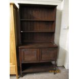 EARLY 20TH CENTURY OAK FRAMED DRESSER WITH TWO FIXED SHELVES AND PANEL BACK WITH TWO CUPBOARD