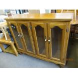 OAK FRAMED BOOKCASE WITH FOUR GLAZED DOORS WITH PORCELAIN KNOB HANDLES