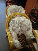 TWO BAMBOO FRAMED ARMCHAIRS WITH FLORAL UPHOLSTERED CUSHIONS