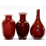 Group of three Chinese sang de beouf vases, one of bottle shape with tapered neck, the other two