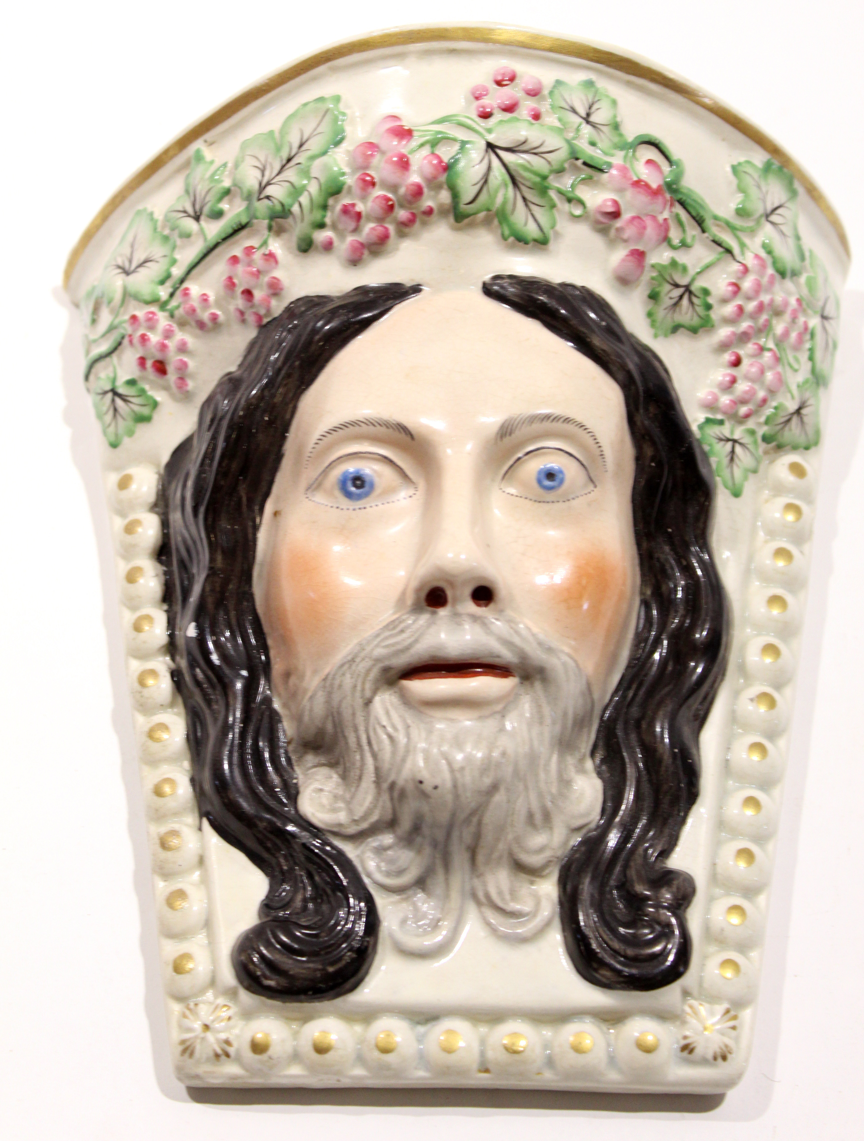 Unusual Staffordshire wall pocket modelled probably as Christ, with a garland of fruit, 24cm long