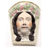 Unusual Staffordshire wall pocket modelled probably as Christ, with a garland of fruit, 24cm long