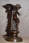 Patinated bronze figure of a seated winged putto with an arrow in his hands (shaft of arrow