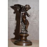 Patinated bronze figure of a seated winged putto with an arrow in his hands (shaft of arrow