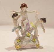 Continental group of three dancing putti on rock work raised on four stub legs