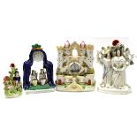 Two Staffordshire watch holder groups, one modelled as a castle, the other flanked by two figures,