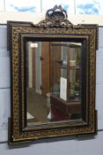 19th century ebonised and parcel gilded wall mirror with shell crested top, 56cm wide