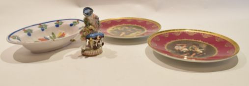 Two Continental plates with printed decoration, together with a Continental porcelain figure in