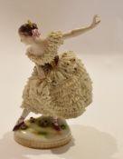 Continental porcelain model of a ballet dancer on shaped oval base, the figure with ceramic flounced