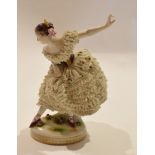 Continental porcelain model of a ballet dancer on shaped oval base, the figure with ceramic flounced