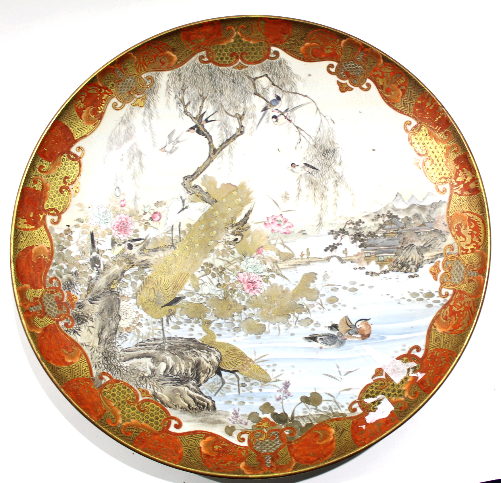 Large Satsuma dish, Meiji period, the centre decorated with a landscape scene and mountains with