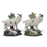 Two mid-19th century Staffordshire models of goats on rocky bases with kids at their feet, (2)