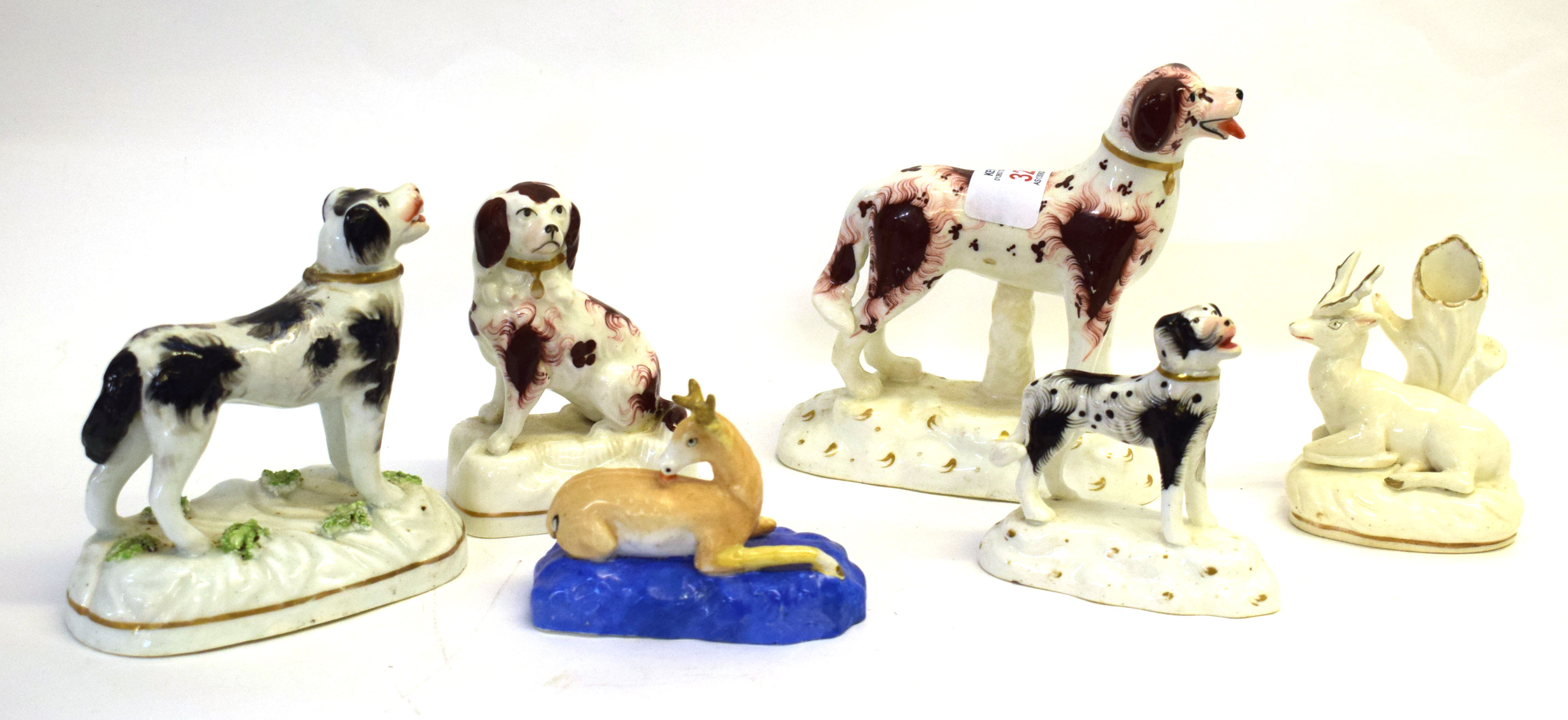 Group of Staffordshire dog models on moulded bases, together with 2 Staffordshire models of deer