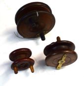 Collection of three early 20th century wooden fishing reels with brass mounts, one impressed "