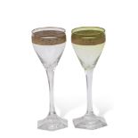 Pair of Continental wine glasses, one stained green, both glasses with a gilt foliate band to