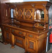 Large light oak mirror back side cabinet, carved throughout with winged griffons, floral scrolls