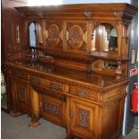 Large light oak mirror back side cabinet, carved throughout with winged griffons, floral scrolls