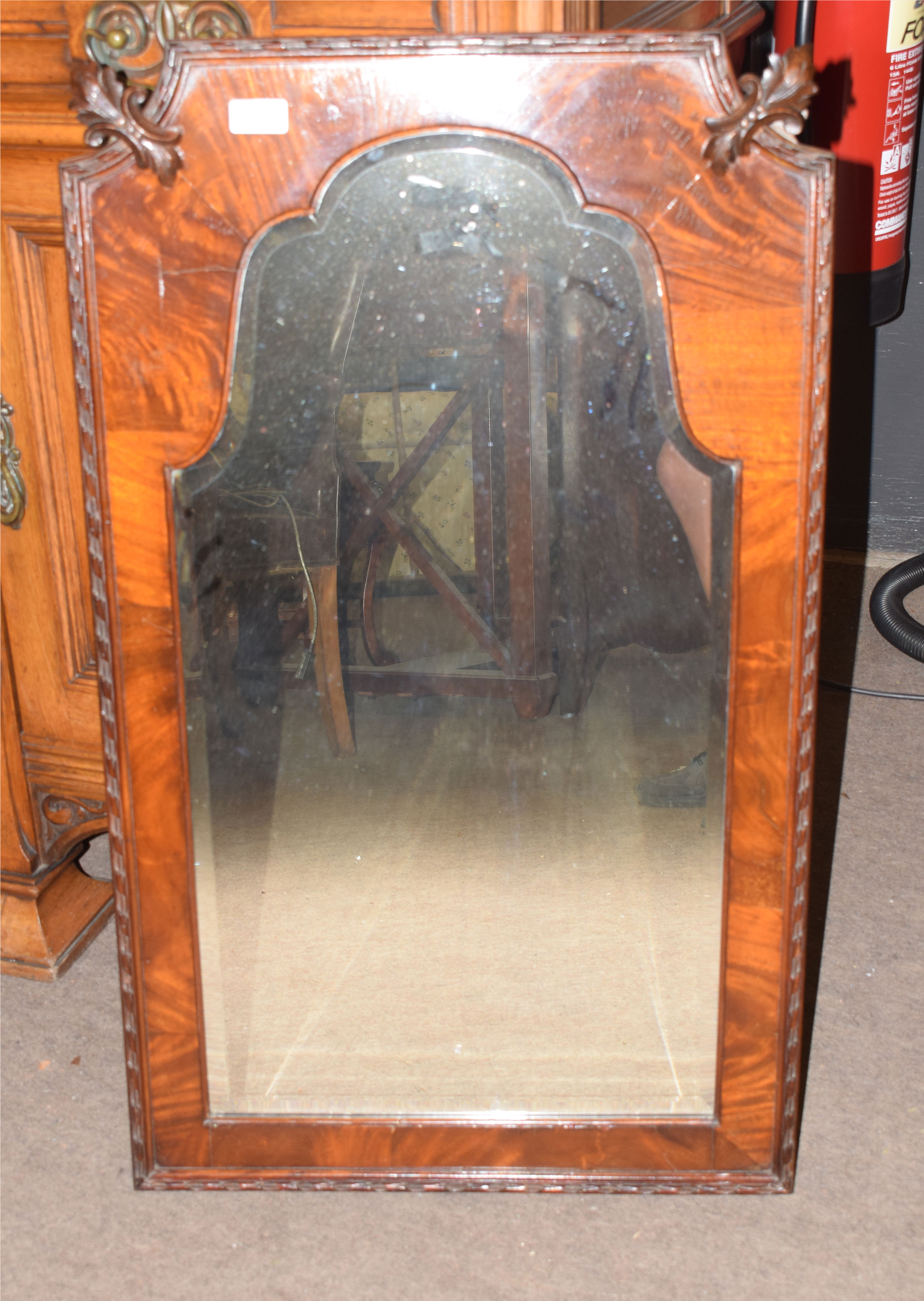 Mahogany wall mirror of arched form with shaped top, the two upper corners carved with acanthus leaf