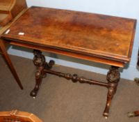 Victorian walnut fold-top card table of rectangular form raised on moulded column supports joined by