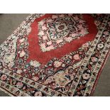 Early/mid-20th century Caucasian wool rug in cream, blue and beige patterns to a red ground with