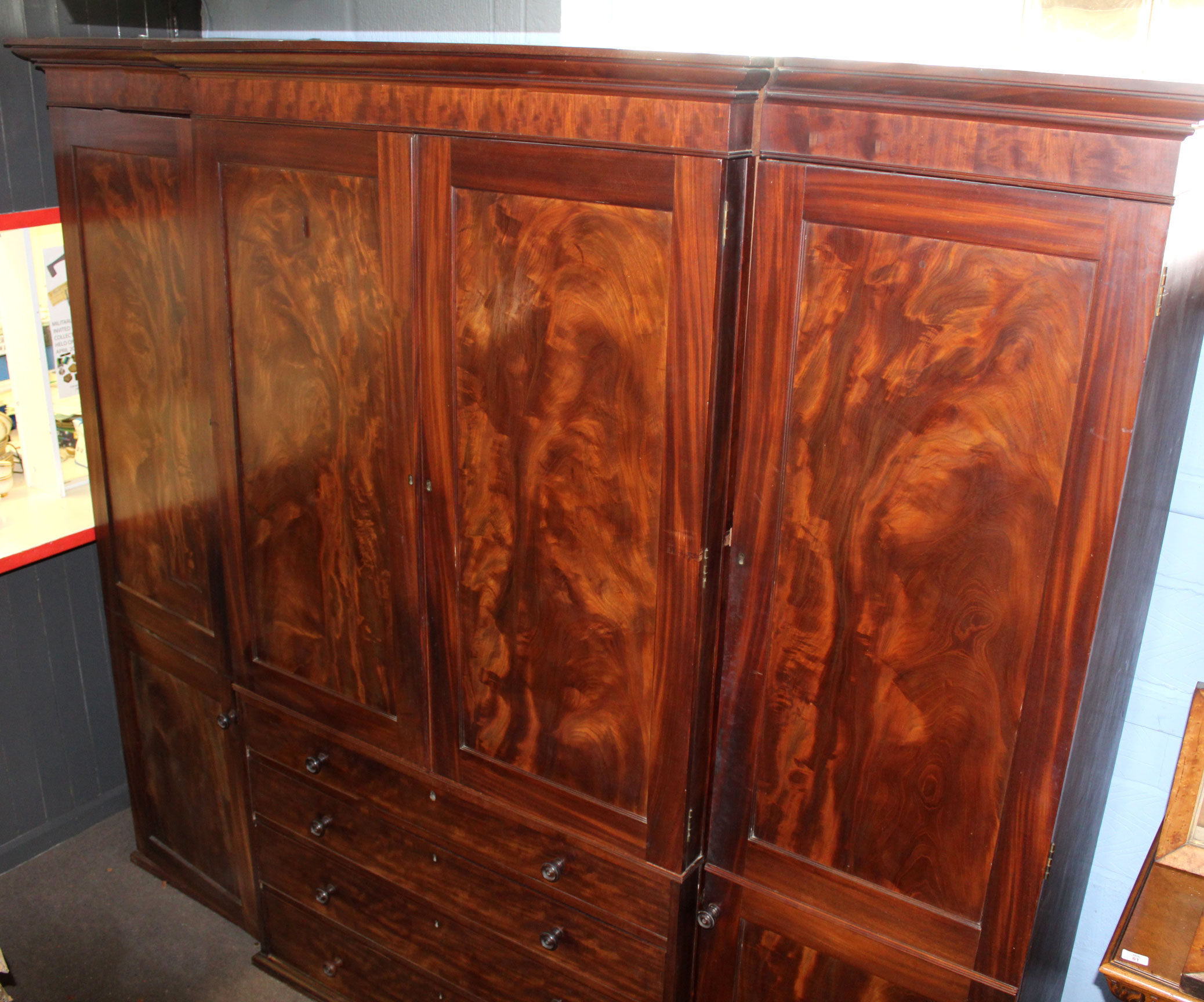 Large Regency period mahogany break front wardrobe moulded corners over central panelled doors