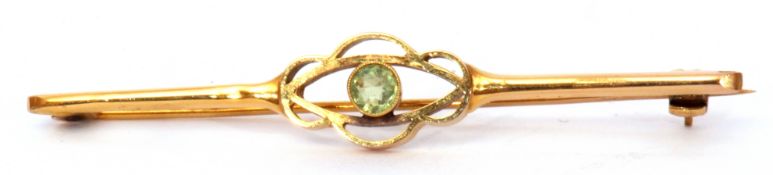 Edwardian 15ct stamped brooch, the open work centre with bezel set peridot, 6cm long, gross weight