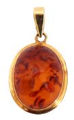 Modern amber pendant, oval cabochon shaped, framed in a 375 stamped mount