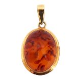 Modern amber pendant, oval cabochon shaped, framed in a 375 stamped mount