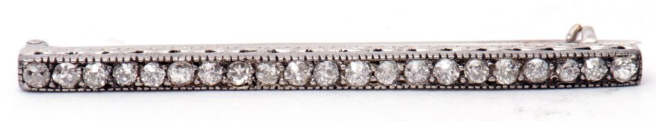 Precious metal diamond set bar brooch, the elongated engraved and pierced bar featuring 21 small old