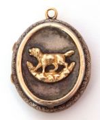 Antique silver oval locket, the front applied with a gold shield engraved with a monogram, the verso