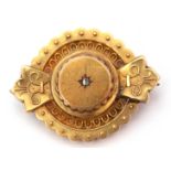 Victorian gold target brooch in Etruscan style, featuring a small central old cut diamond, glazed