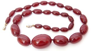 Cherry amber bead necklace, a single graduated row of oblong shaped beads, 1-3cm diam to a metal