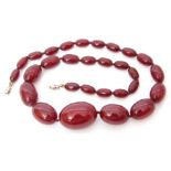 Cherry amber bead necklace, a single graduated row of oblong shaped beads, 1-3cm diam to a metal