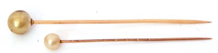 Two yellow metal and simulated pearl stick pins, cased