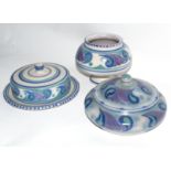 Three pieces of mid-20th century Poole Pottery vases decorated in tones of blue and green with a