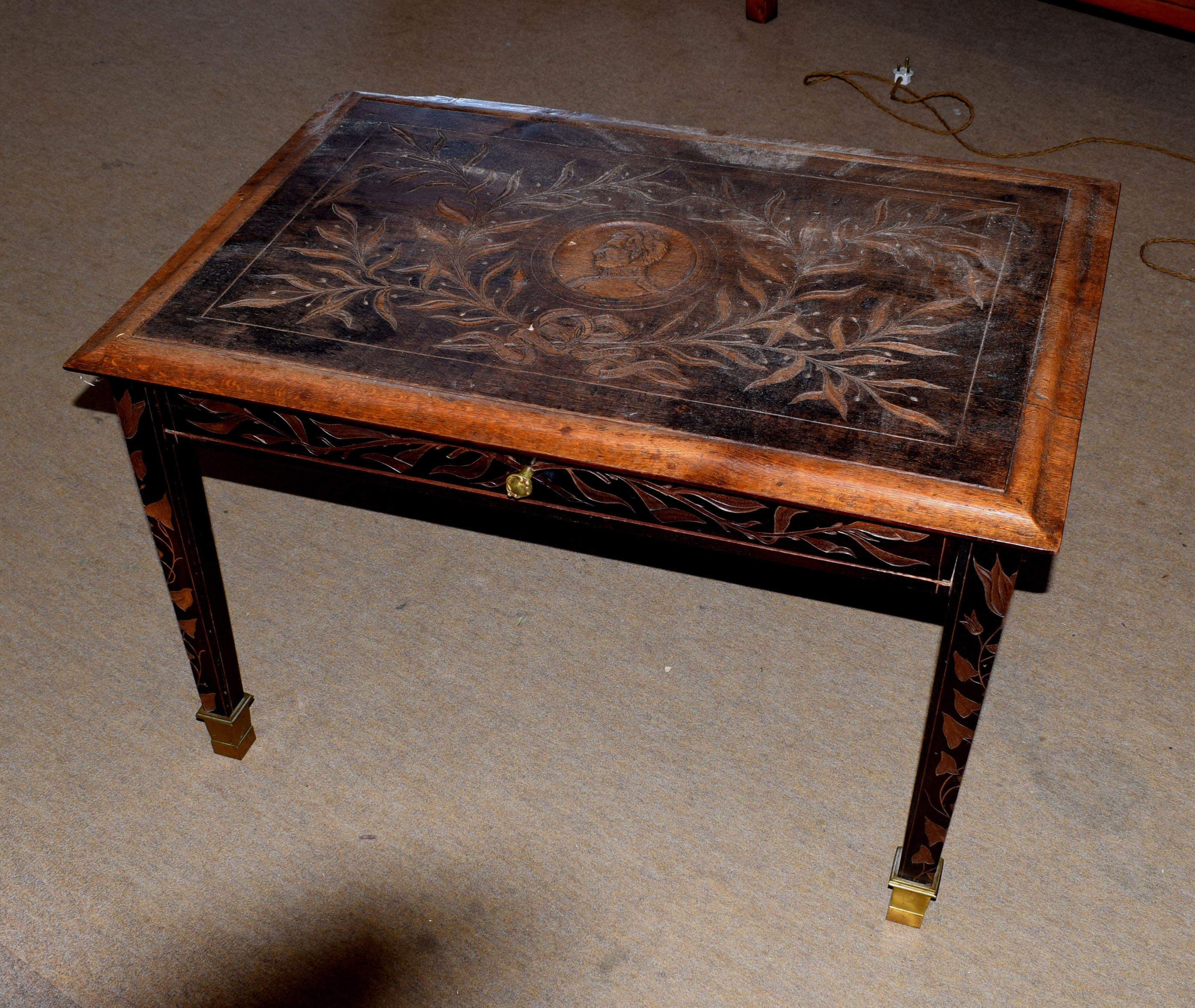 20th century coffee table with drawer, the top carved with leaves and portrait, inscribed "Albert