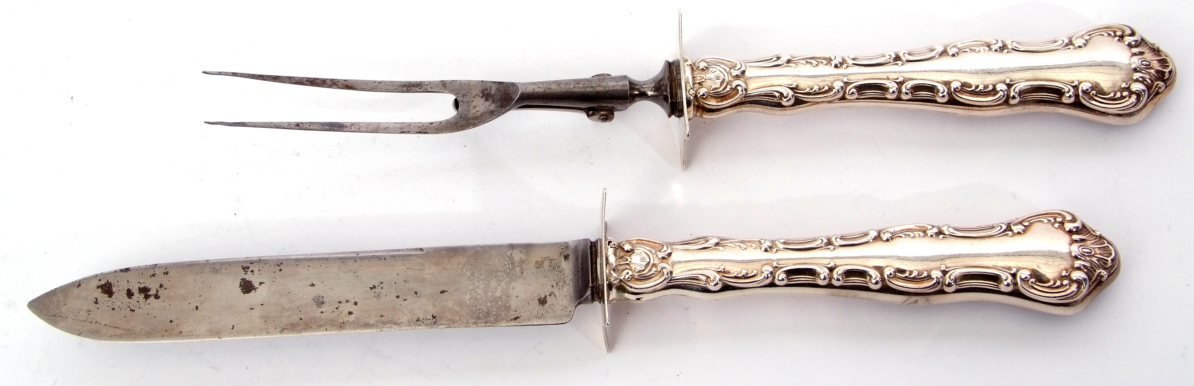 Pair of Edward VII steel bladed carvers with decorative scroll embossed silver encased handle, the