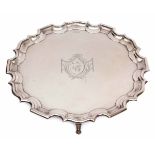 George V plain small silver waiter of circular form with "Chippendale" edge and supported on four