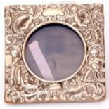 Victorian small silver photograph frame of square form, elaborately decorated with cherubs,