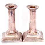 Pair of Edward VII dwarf loaded candlesticks, the neo-classical columns on stepped bases with