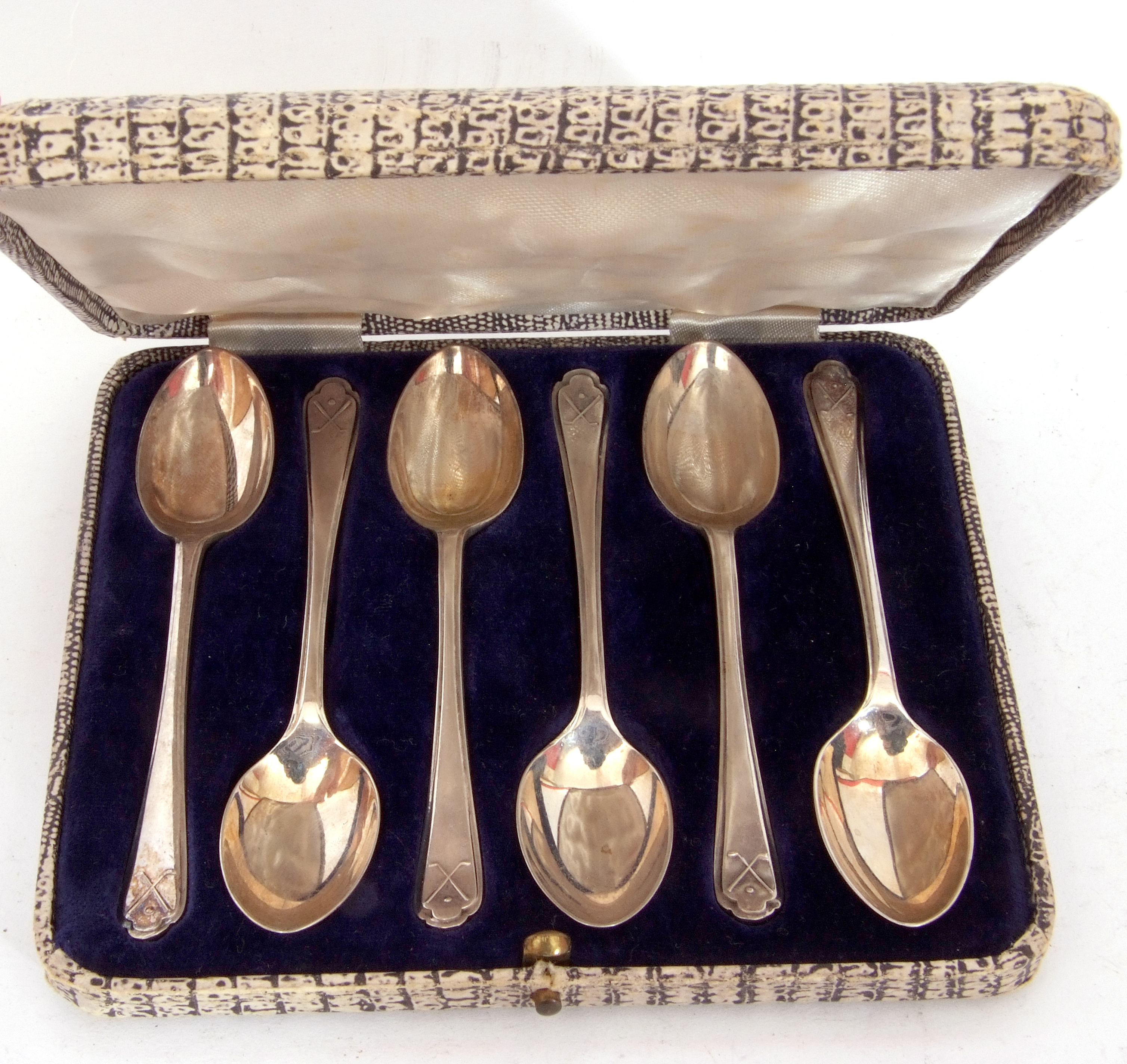 George V cased matching six silver golf tea spoons with embossed crossed golf clubs and ball at