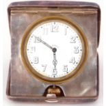 George V silver cased travelling clock the plain polished case with hinged door, the clock with