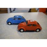 Two Tonka models of Volkswagen Beetles, one in red, the other in blue livery