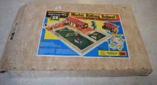 Boxed Britain's model riding school kit, including riding stable, tack room, jumps gates, trees